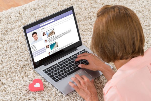 Close-up Of Woman With Heart Sign Chatting On Social Networking Site On Laptop